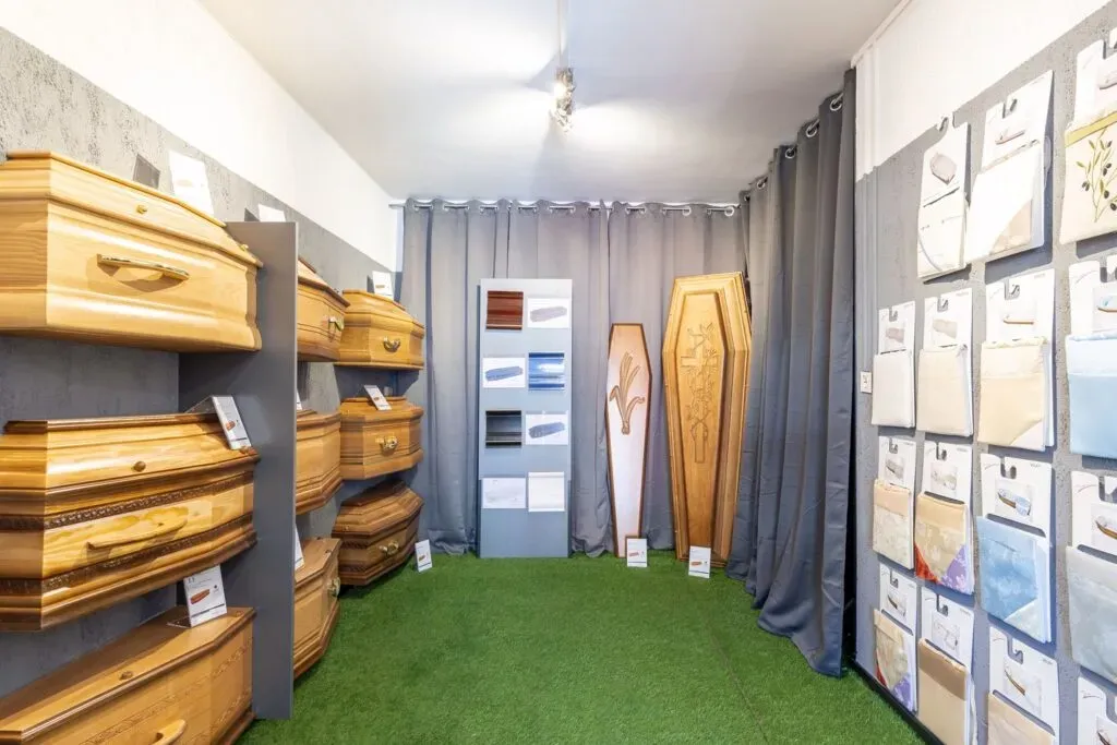 Salle d'exposition de cercueils en bois et capitons pour l'organisation d'obsèques.